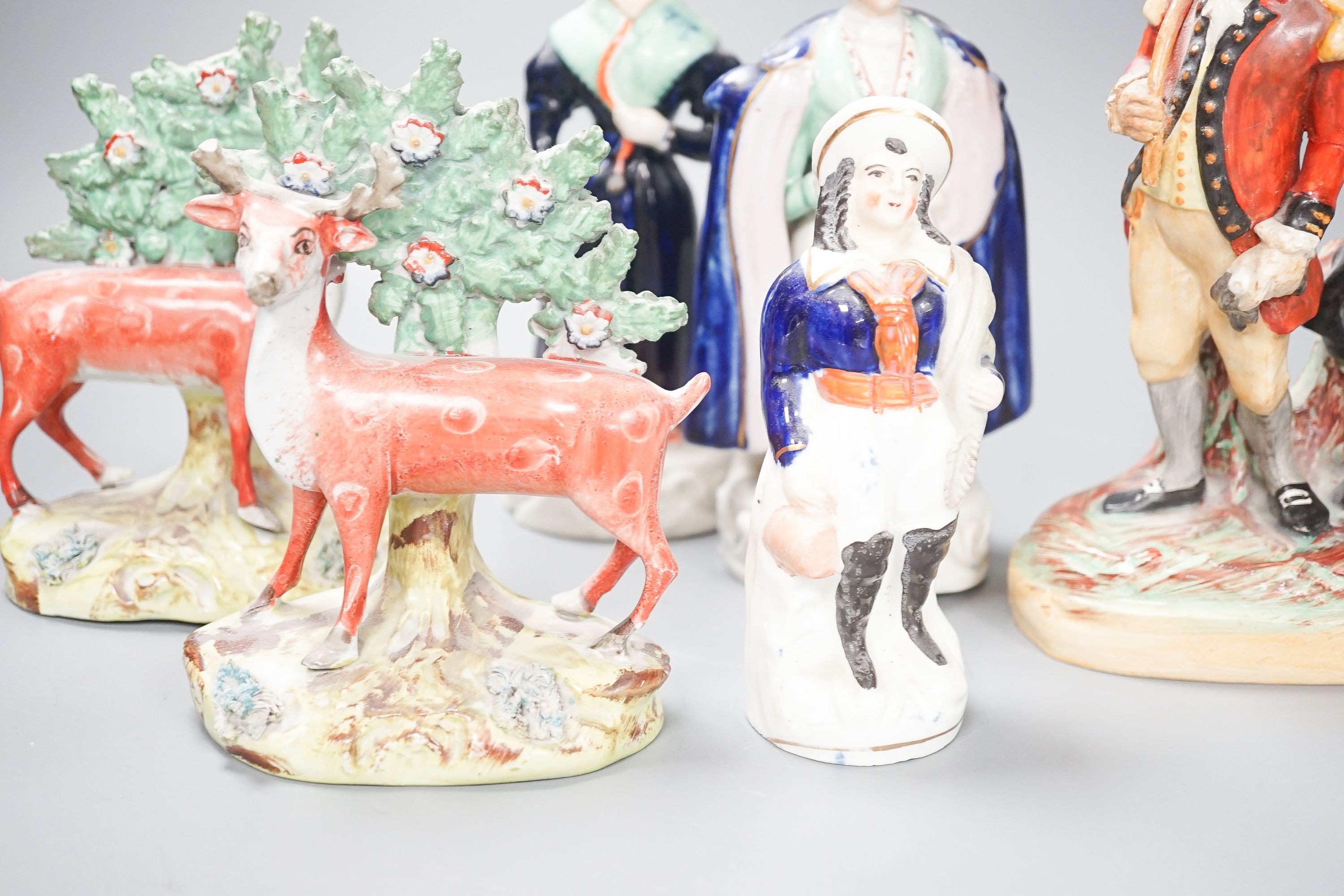 A group of Staffordshire figures, including a pair of deer standing before bocage, 15cm, a Victorian couple, 19 cm and a golfing group, 20 cm (6)